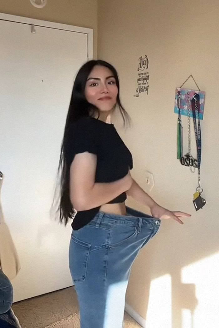 Sara holding out the waist of her old jeans, showing how loose they are